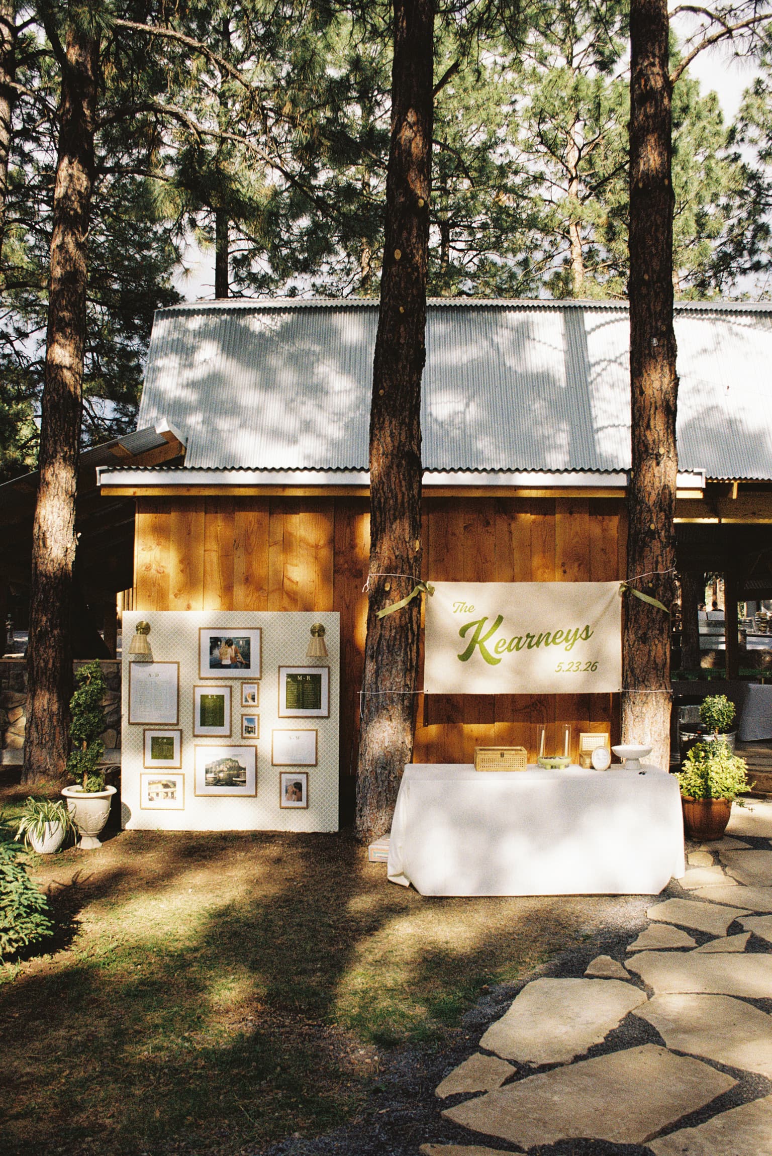 Welcome and seating-chart display with framed photos and a The Kearneys banner set in front of the cabin